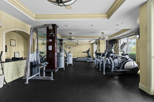 workout area with crown molding and a tray ceiling