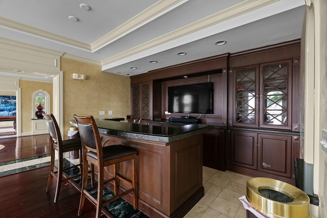 bar featuring crown molding and light hardwood / wood-style flooring