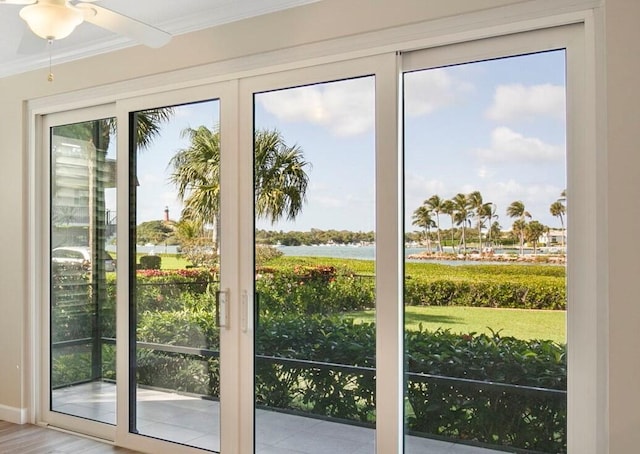 doorway to outside featuring a water view, light hardwood / wood-style flooring, ceiling fan, and crown molding