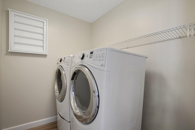 laundry room featuring hardwood / wood-style flooring and washer and dryer