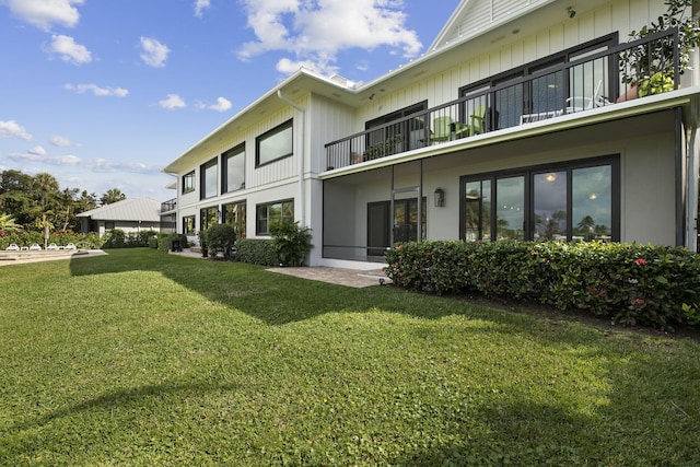 rear view of property featuring a lawn