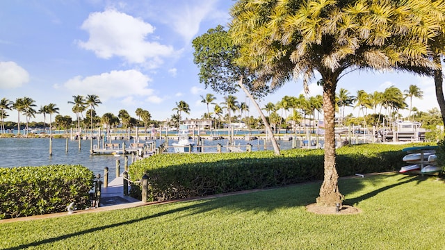 view of dock with a lawn and a water view