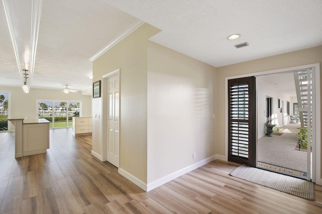 entryway featuring a textured ceiling, light wood-type flooring, and ceiling fan