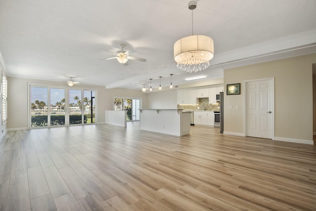 unfurnished living room with ceiling fan with notable chandelier, rail lighting, crown molding, light hardwood / wood-style flooring, and a textured ceiling