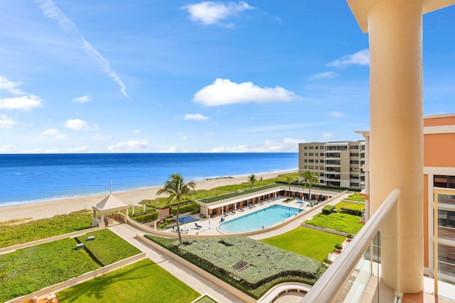 balcony with a water view and a view of the beach