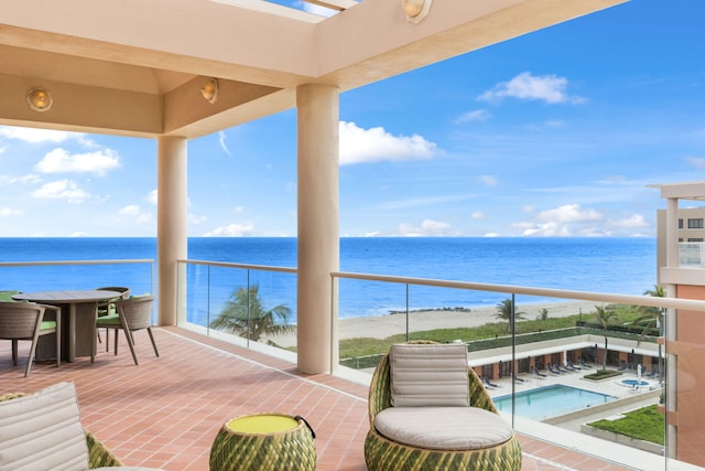 balcony with a water view and a view of the beach