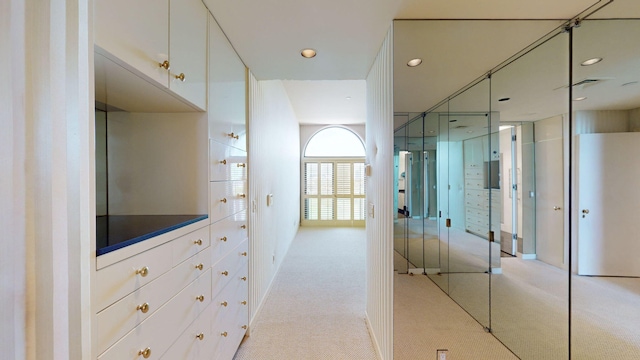 hallway featuring light colored carpet