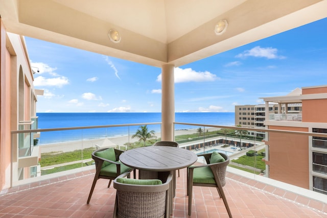 balcony featuring a water view and a beach view