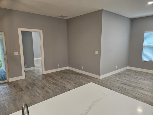 unfurnished room with hardwood / wood-style flooring