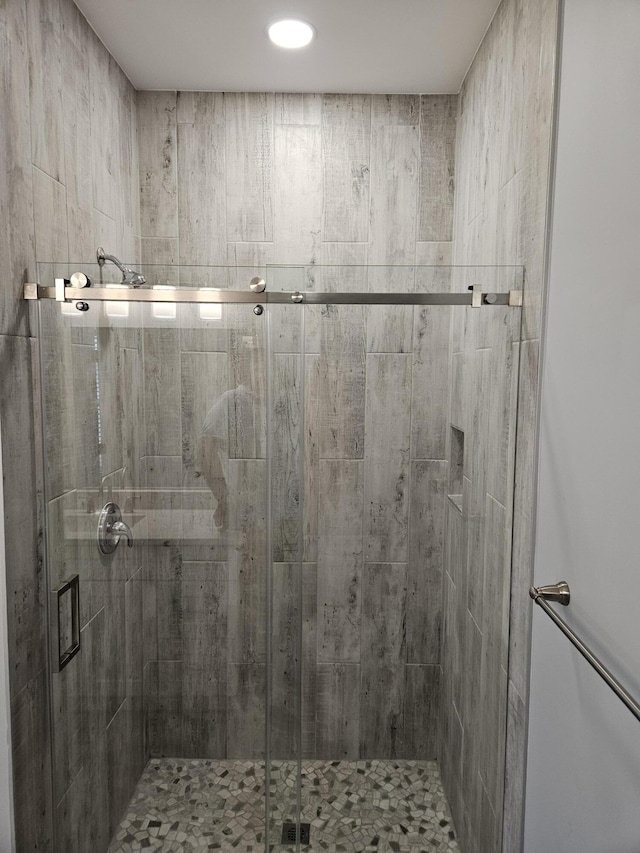 bathroom with a shower with door