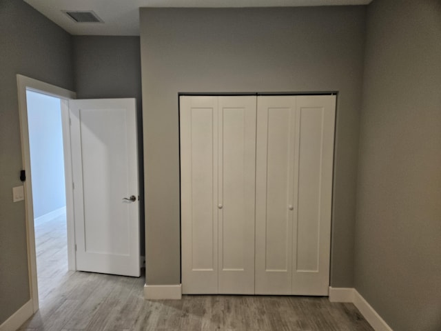 unfurnished bedroom featuring light wood-type flooring and a closet