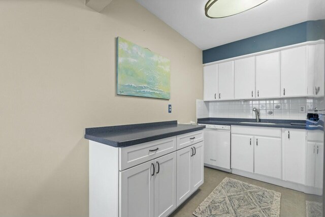 kitchen with white cabinetry, sink, white dishwasher, and decorative backsplash