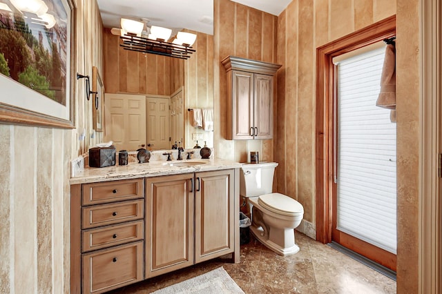 bathroom with a healthy amount of sunlight, vanity, toilet, and a notable chandelier