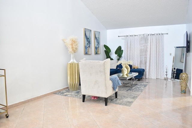 living area featuring a textured ceiling, vaulted ceiling, and light tile patterned flooring