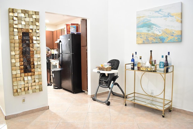 kitchen with black refrigerator and light tile patterned flooring