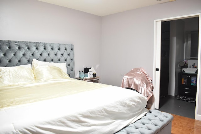 bedroom with hardwood / wood-style floors and sink