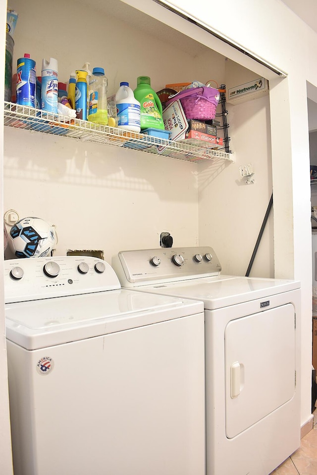 clothes washing area with light tile patterned floors and washing machine and clothes dryer