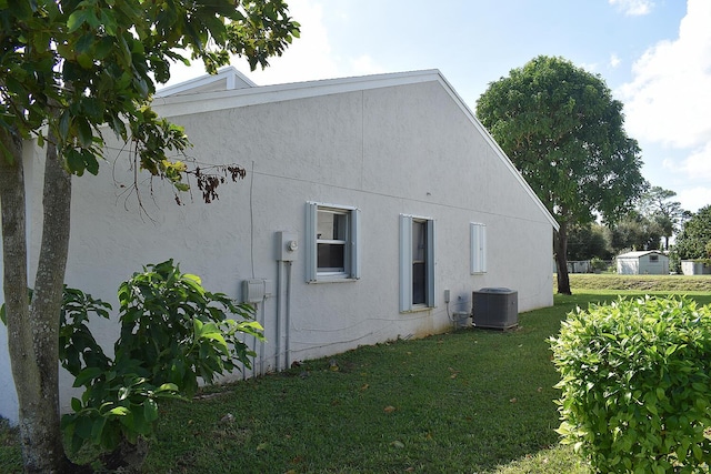 view of property exterior with a yard and central AC