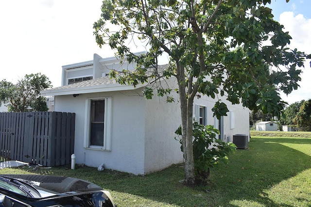 view of side of home featuring a lawn and central air condition unit