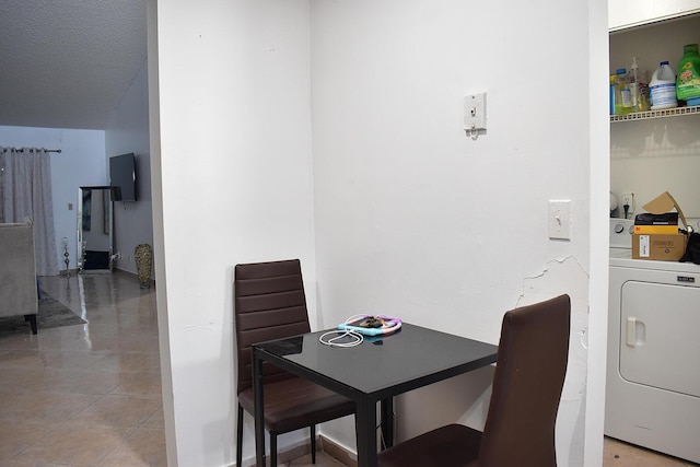 dining space with light tile patterned floors, a textured ceiling, and washer / dryer