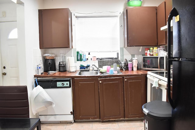 kitchen with dark brown cabinetry, white appliances, backsplash, and light tile patterned floors