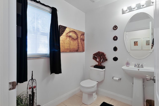 bathroom with toilet, tile patterned floors, and sink