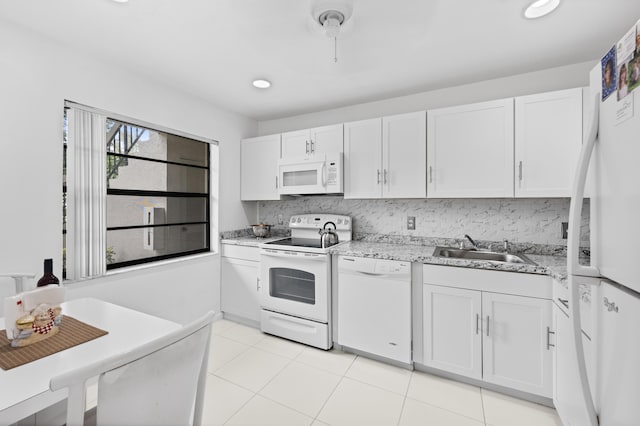 kitchen featuring decorative backsplash, light stone counters, white appliances, sink, and white cabinetry