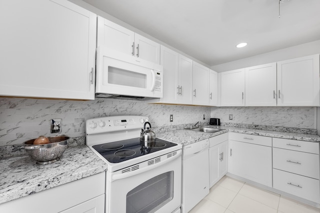 kitchen with white cabinetry, white appliances, sink, and light tile patterned floors