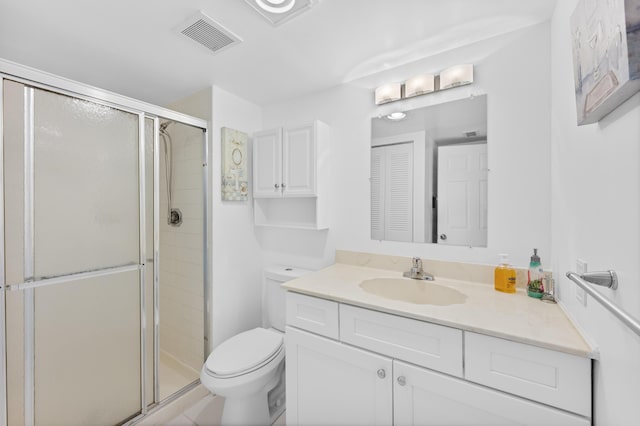 bathroom with an enclosed shower, vanity, and toilet