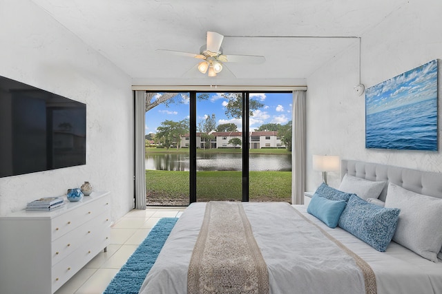 tiled bedroom featuring access to exterior, a water view, and ceiling fan