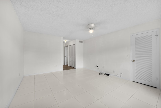 empty room featuring light tile patterned floors and a textured ceiling