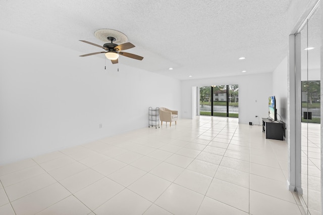 unfurnished room featuring a textured ceiling, ceiling fan, and light tile patterned flooring