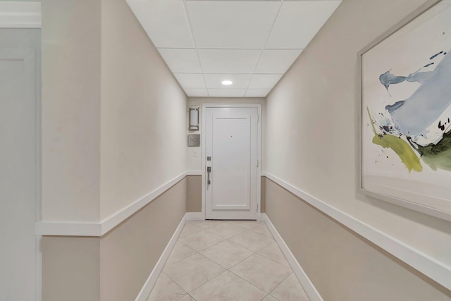 doorway to outside featuring a drop ceiling and light tile patterned floors