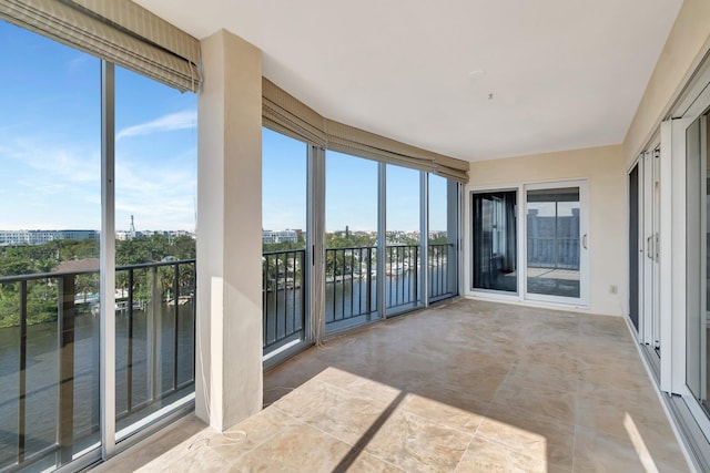 unfurnished sunroom featuring a water view and plenty of natural light