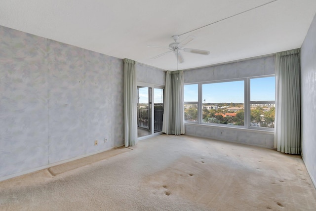 empty room featuring ceiling fan and light carpet