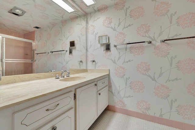 bathroom with tile patterned floors, an enclosed shower, and vanity