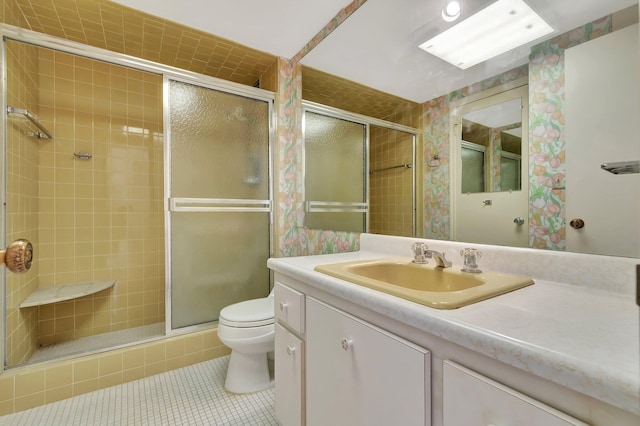 bathroom featuring vanity, tile patterned flooring, a shower with door, and toilet