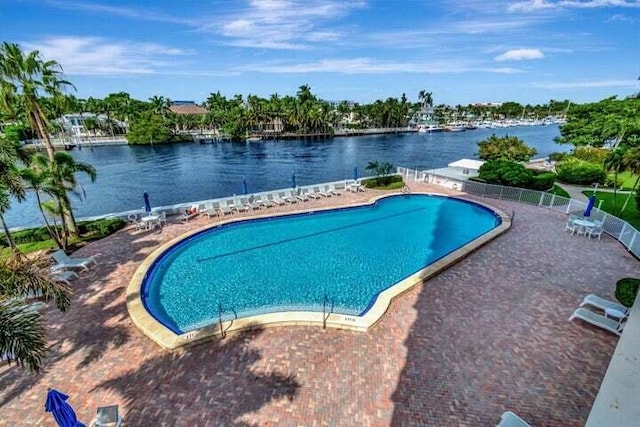 view of pool with a water view and a patio