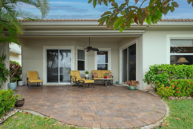 entrance to property with a patio area, ceiling fan, and outdoor lounge area