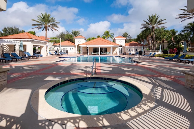 view of swimming pool featuring a patio area and a community hot tub