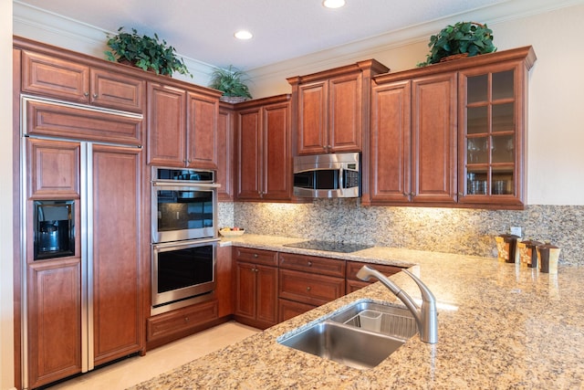 kitchen with backsplash, crown molding, sink, light stone counters, and stainless steel appliances