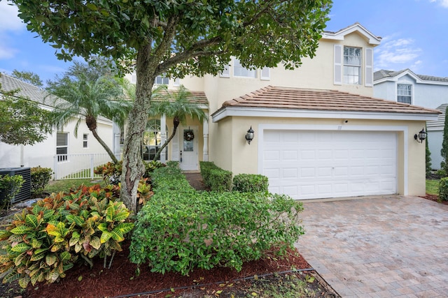 view of front of house featuring a garage and central AC