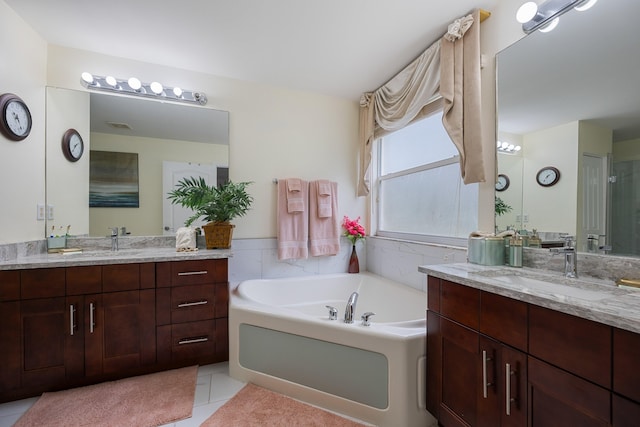 bathroom featuring a bathing tub, tile patterned flooring, and vanity