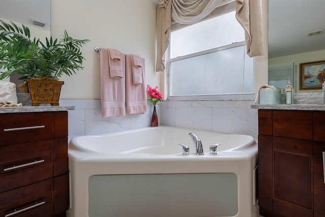 bathroom with vanity and a bath