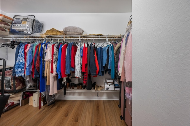 walk in closet with hardwood / wood-style floors