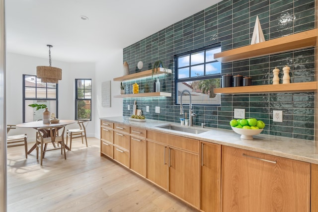 kitchen with decorative light fixtures, sink, a wealth of natural light, and tasteful backsplash