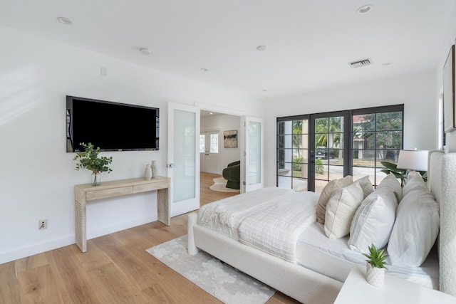 bedroom featuring light wood-type flooring and french doors