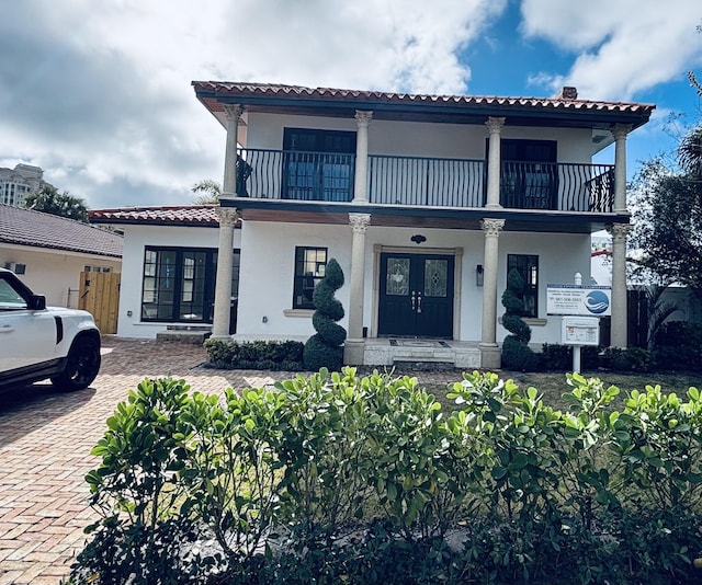 mediterranean / spanish house featuring a porch and a balcony