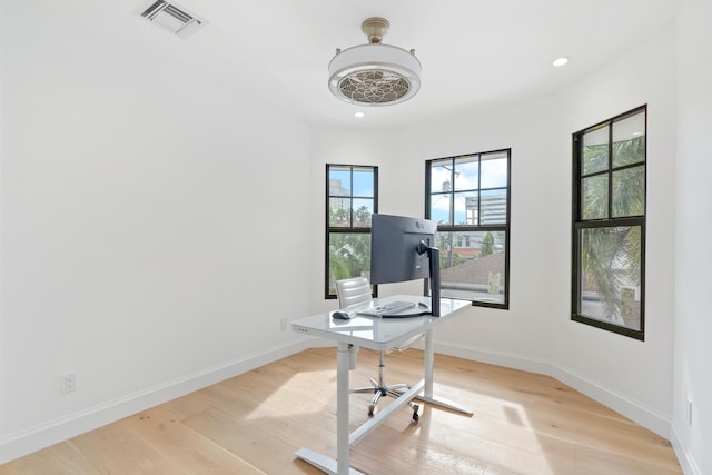 home office with light hardwood / wood-style flooring