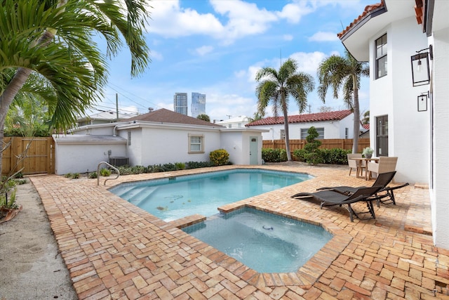 view of pool featuring central AC, a patio, and an in ground hot tub